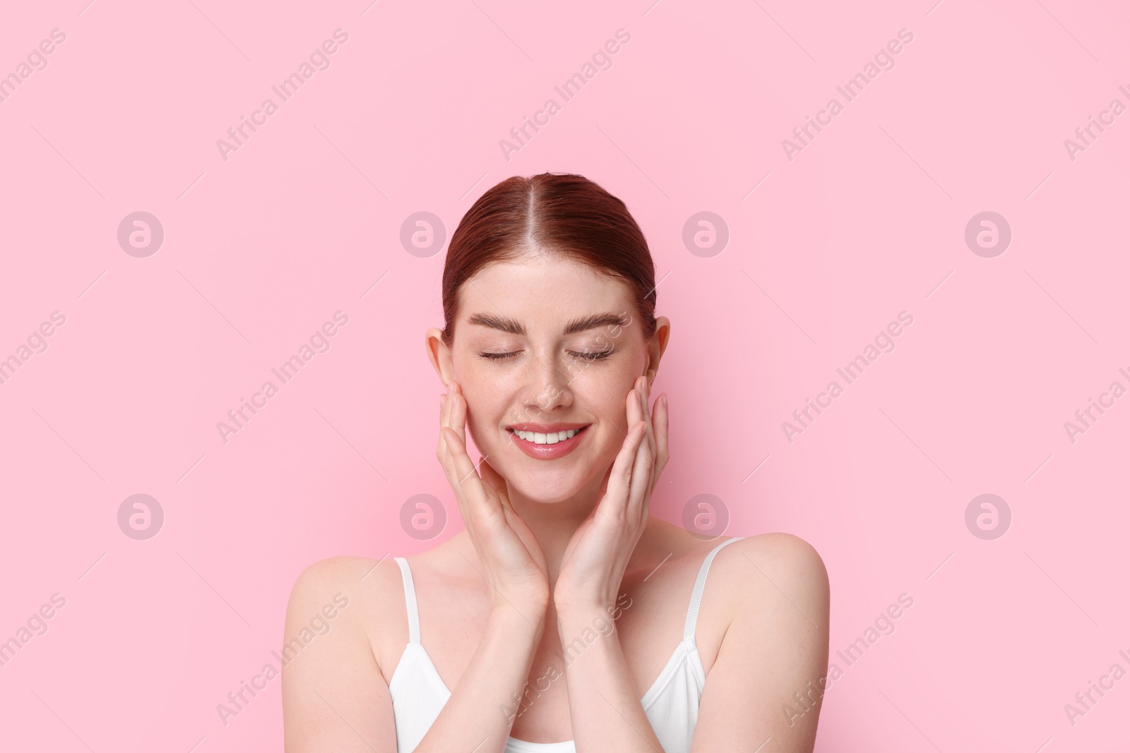 Photo of Portrait of smiling woman on pink background