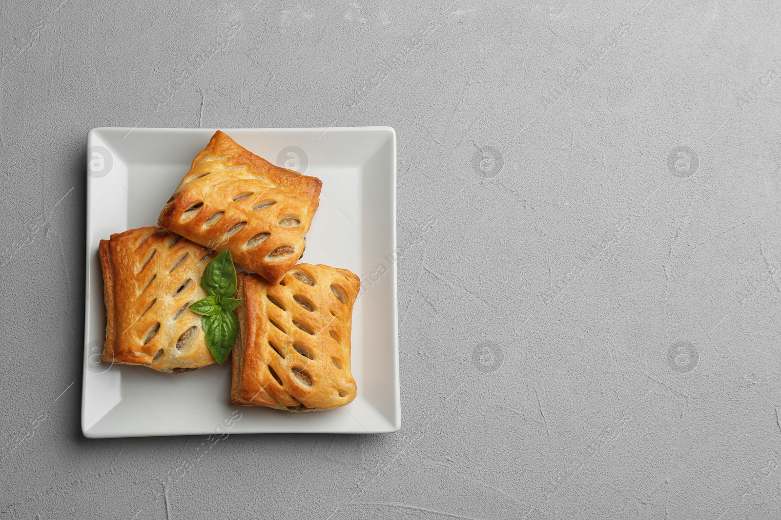 Photo of Fresh delicious puff pastry on grey table, top view. Space for text