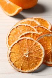 Photo of Dry orange slices on white wooden table, closeup