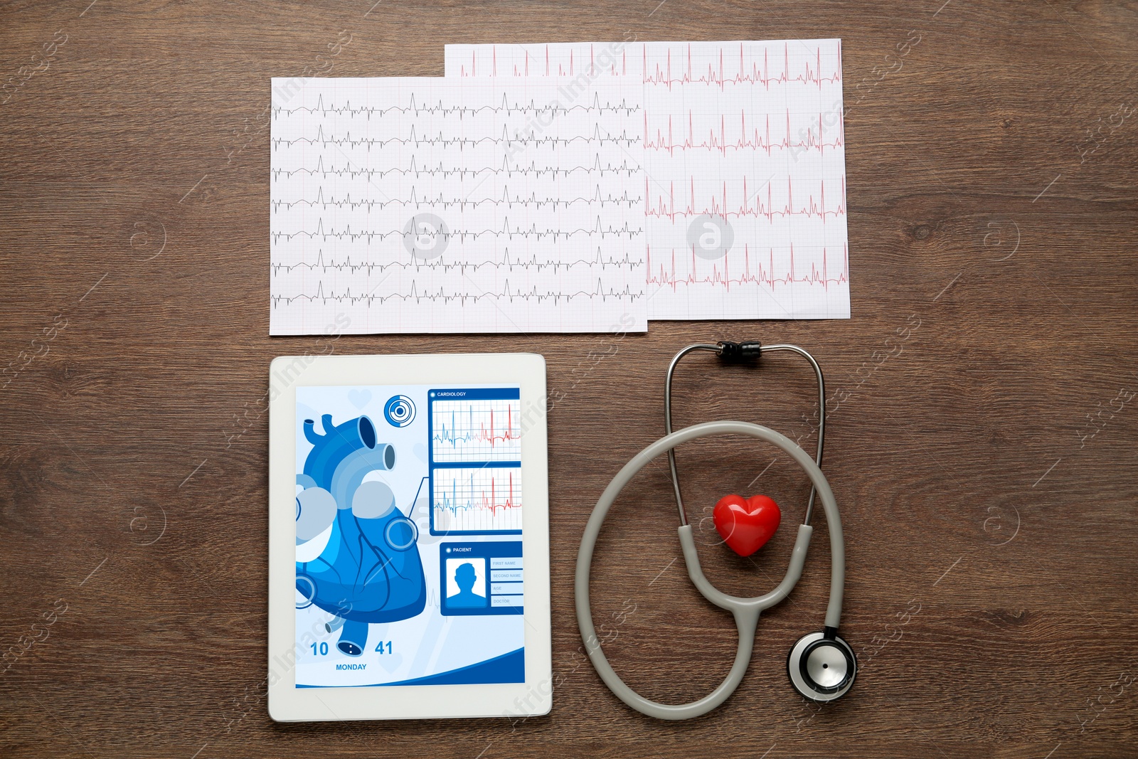 Photo of Flat lay composition with tablet and red heart on wooden table. Cardiology concept