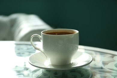 Photo of Cup of delicious aromatic coffee on table indoors, closeup