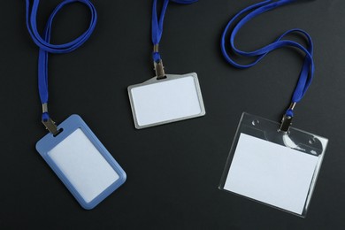 Photo of Blank badges on black background, flat lay. Mockup for design