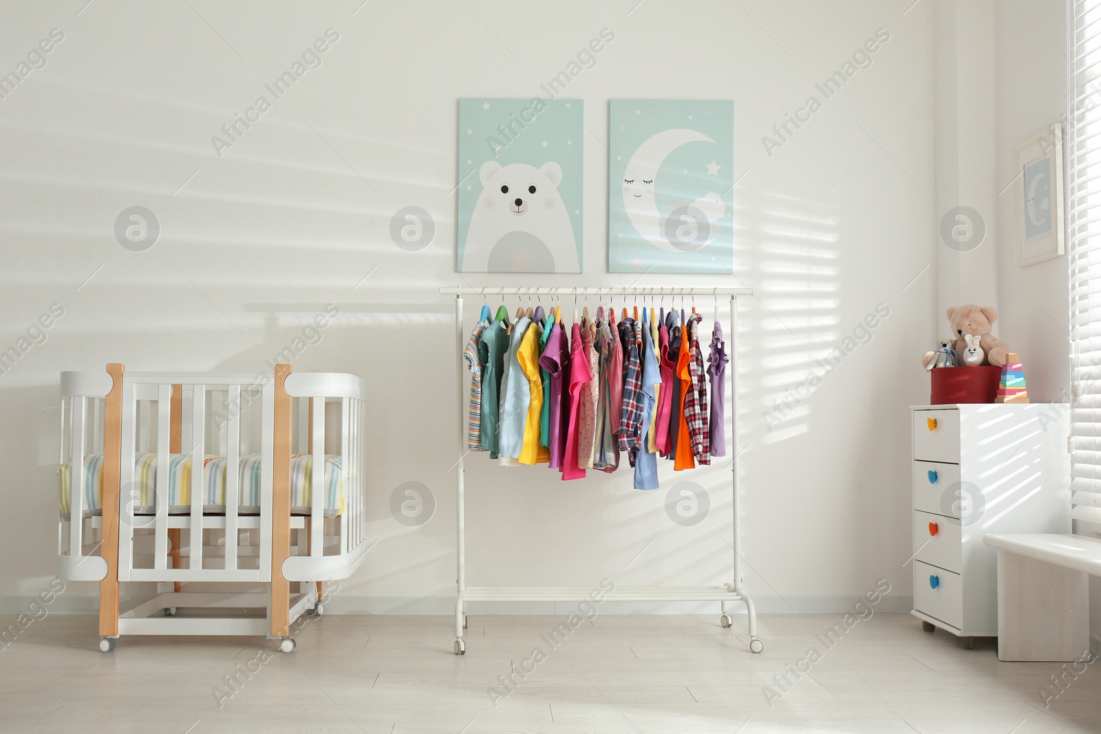 Photo of Different clothes hanging on rack in bedroom