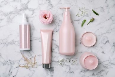Photo of Flat lay composition with hair cosmetic products on white marble table