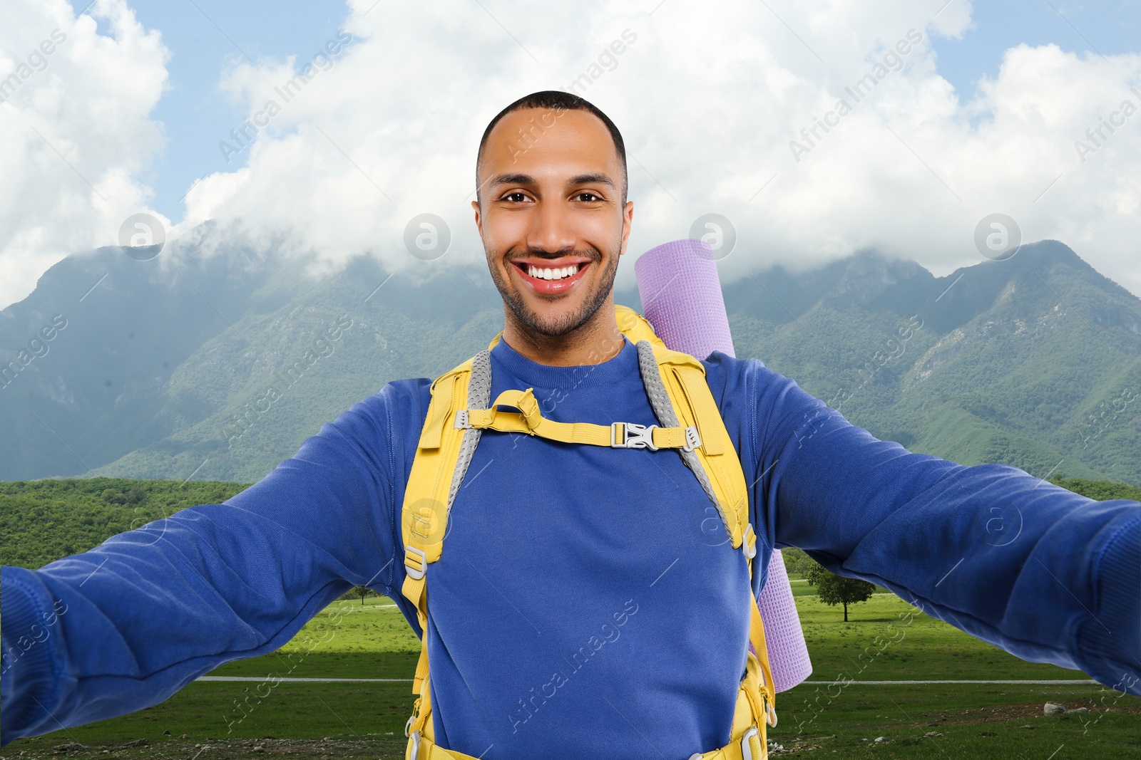 Image of Happy tourist with backpack taking selfie in mountains