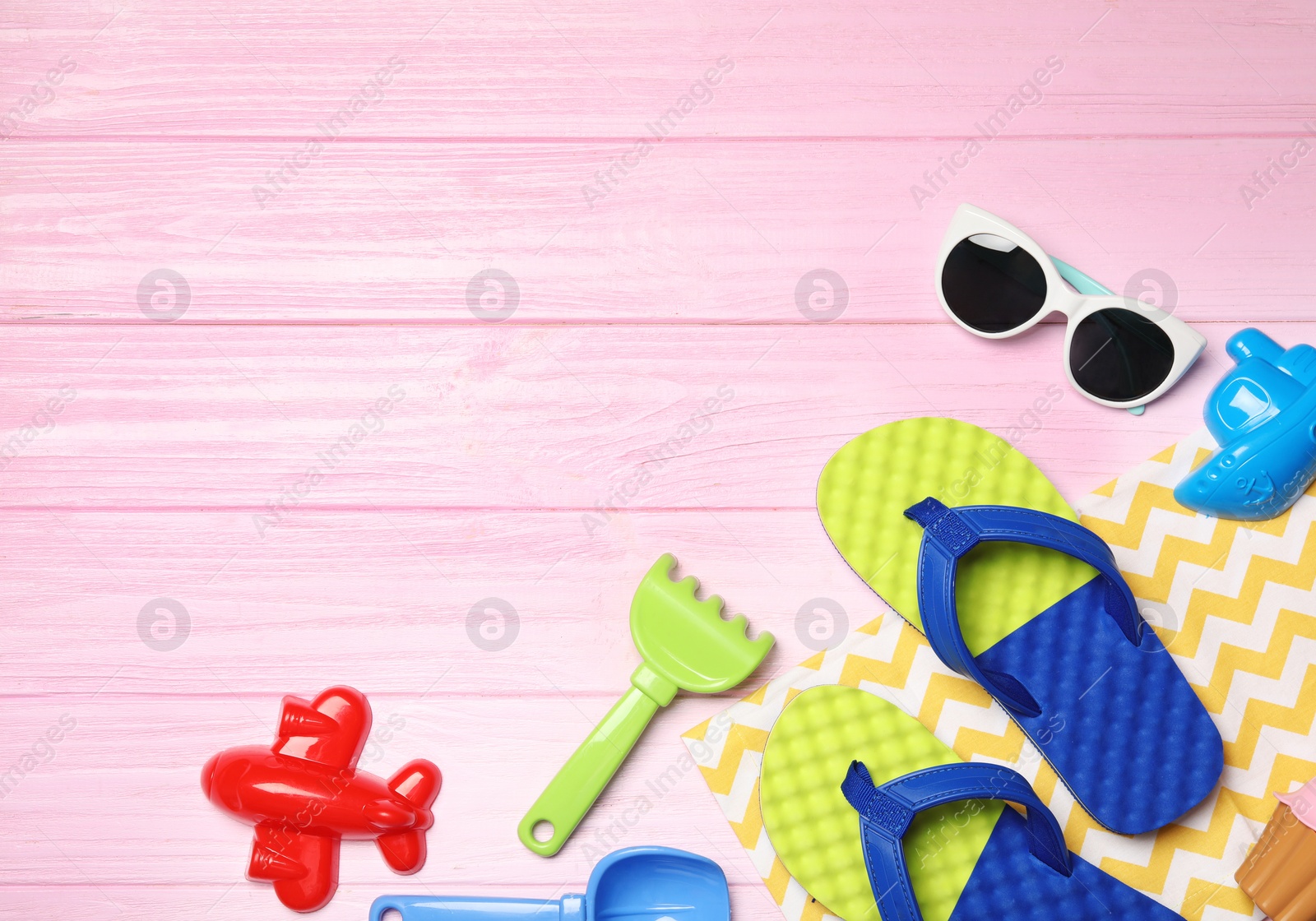 Photo of Flat lay composition with beach toys on color wooden background. Space for text