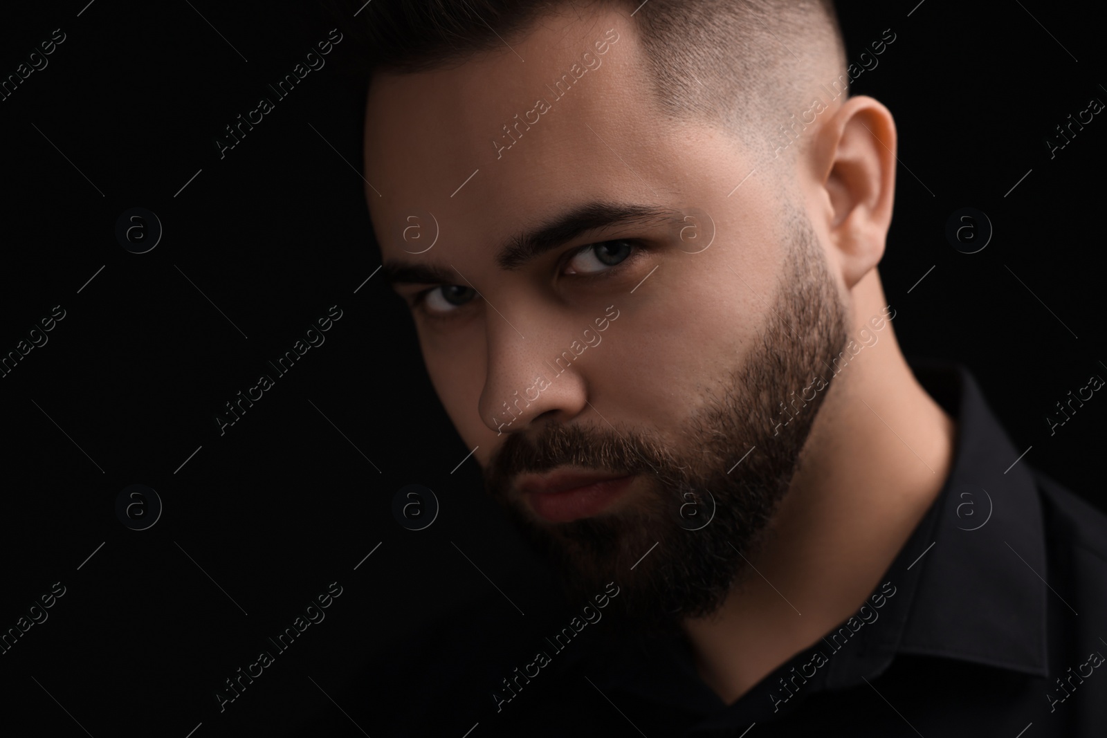 Photo of Evil eye. Man with scary eyes on black background, space for text