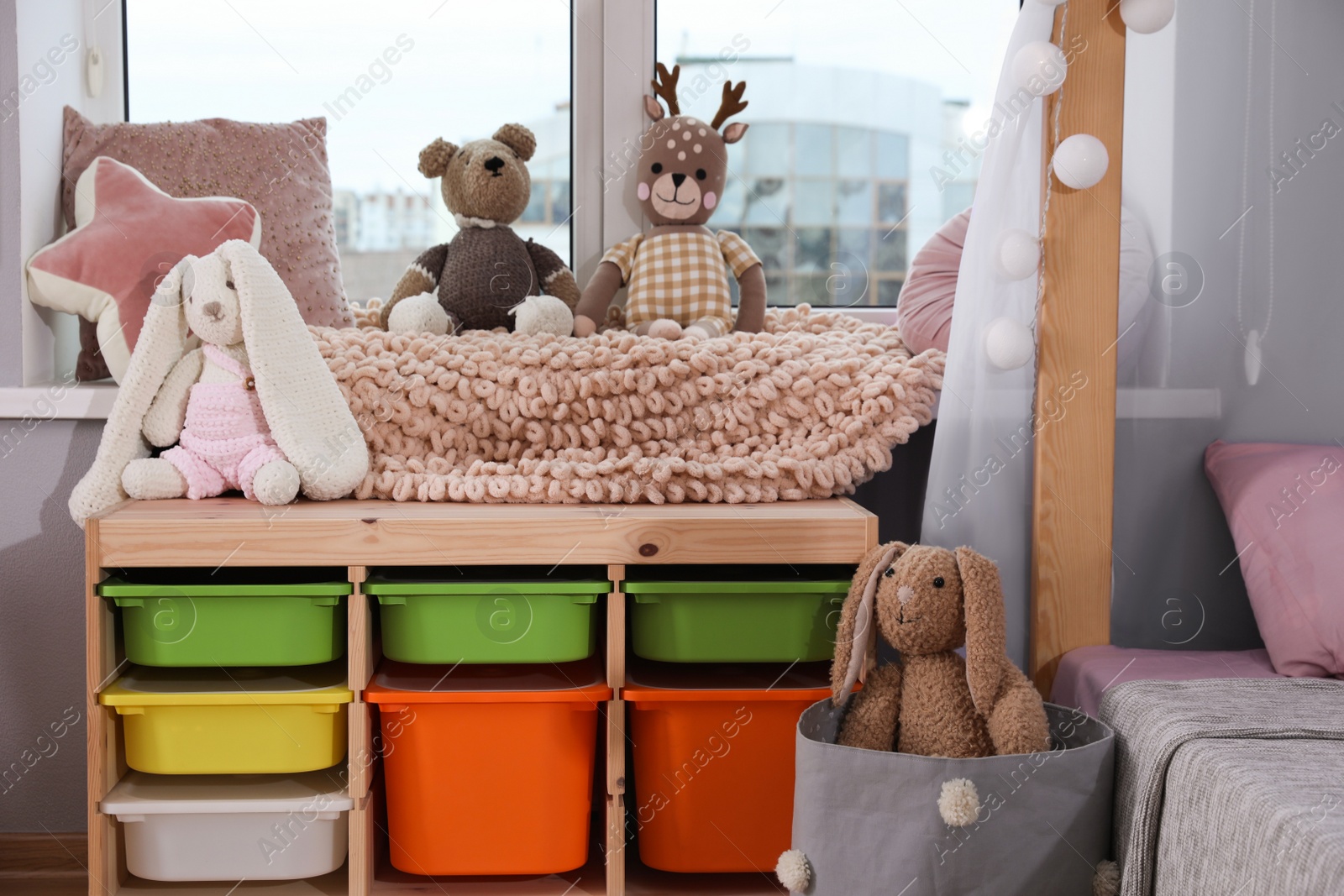 Photo of Stylish child room with storage for toys near window