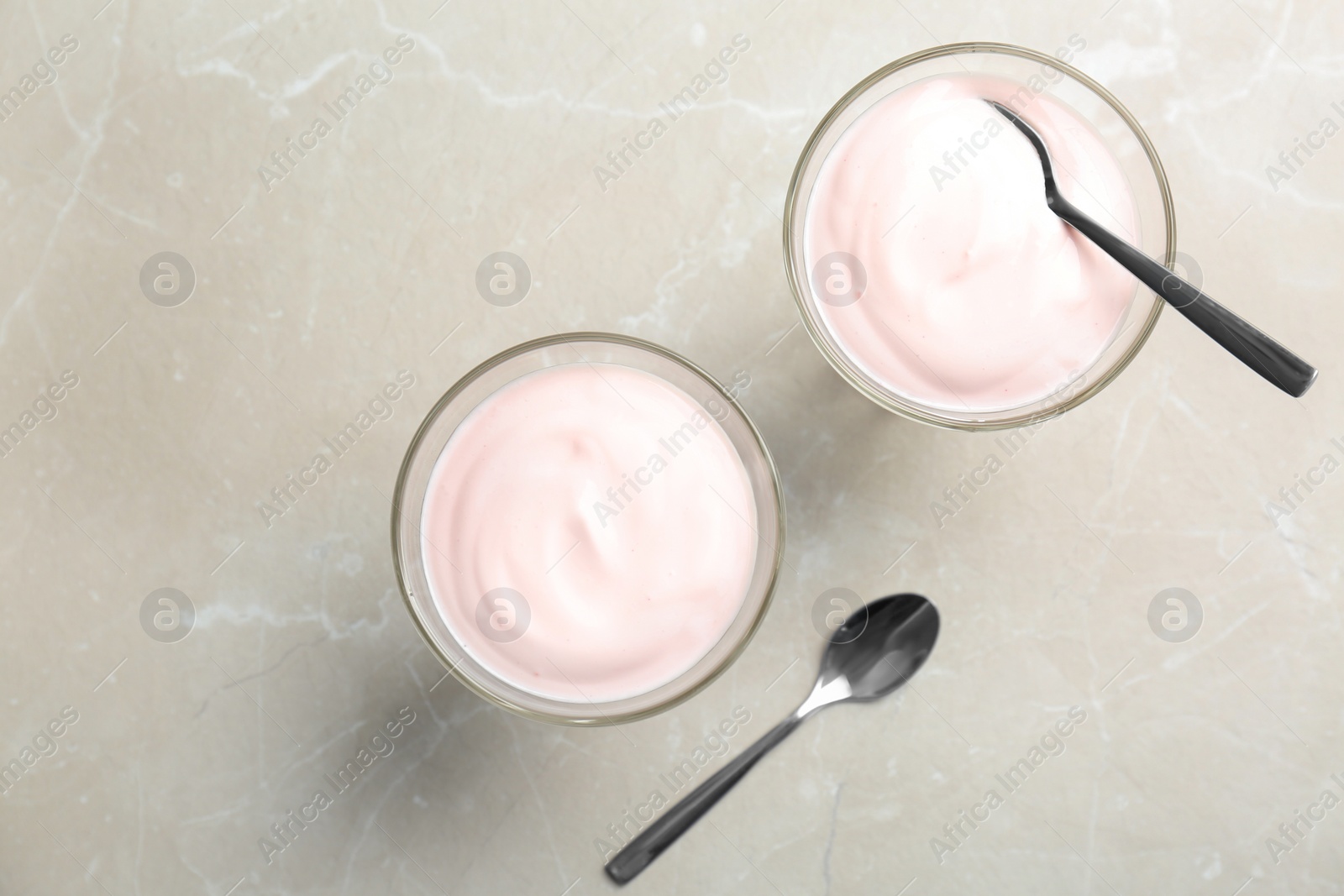 Photo of Glass dessert bowls with yummy yogurt on table