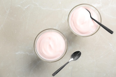 Photo of Glass dessert bowls with yummy yogurt on table