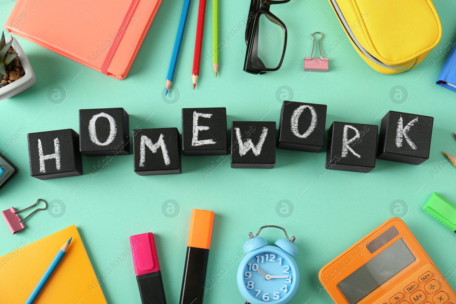 Photo of Flat lay composition with word HOMEWORK made of black cubes on green background