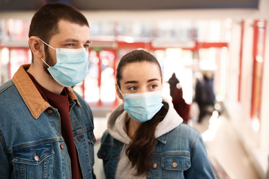 Photo of Couple wearing disposable masks in mall. Dangerous virus