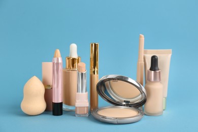 Foundation makeup products on light blue background. Decorative cosmetics