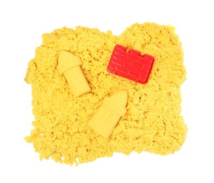 Photo of Yellow kinetic sand and toy on white background, top view