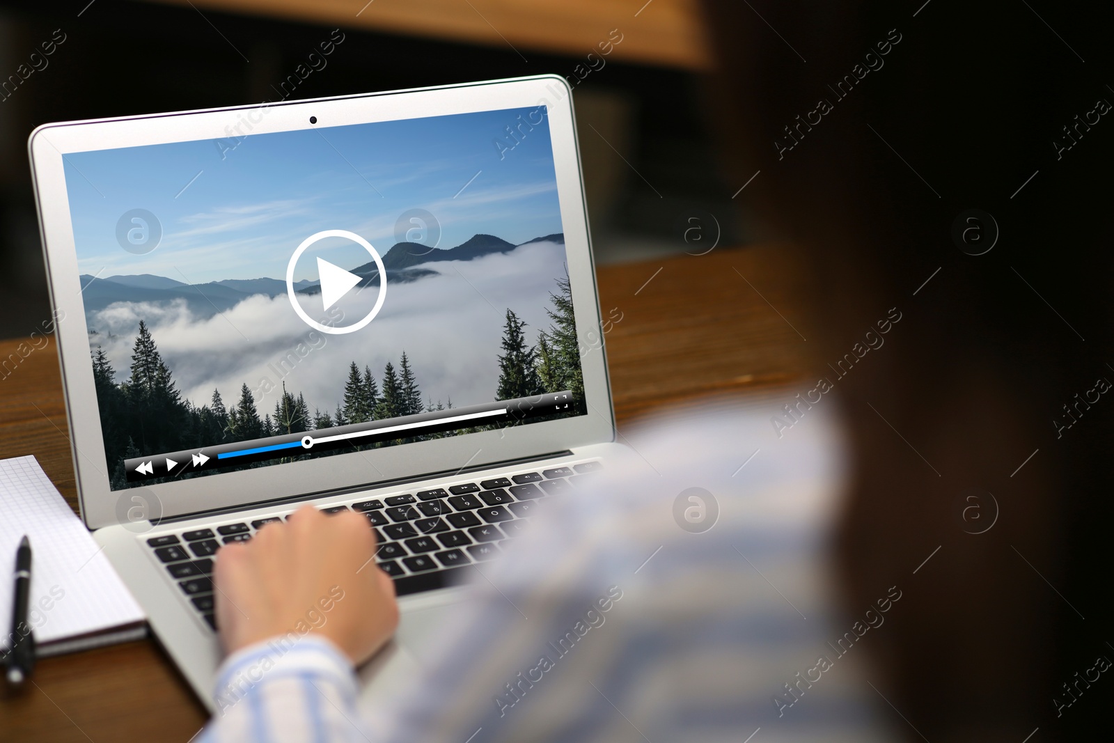 Image of Woman watching video on laptop at office desk, closeup