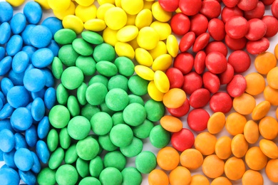 Photo of Many colorful candies as background, top view