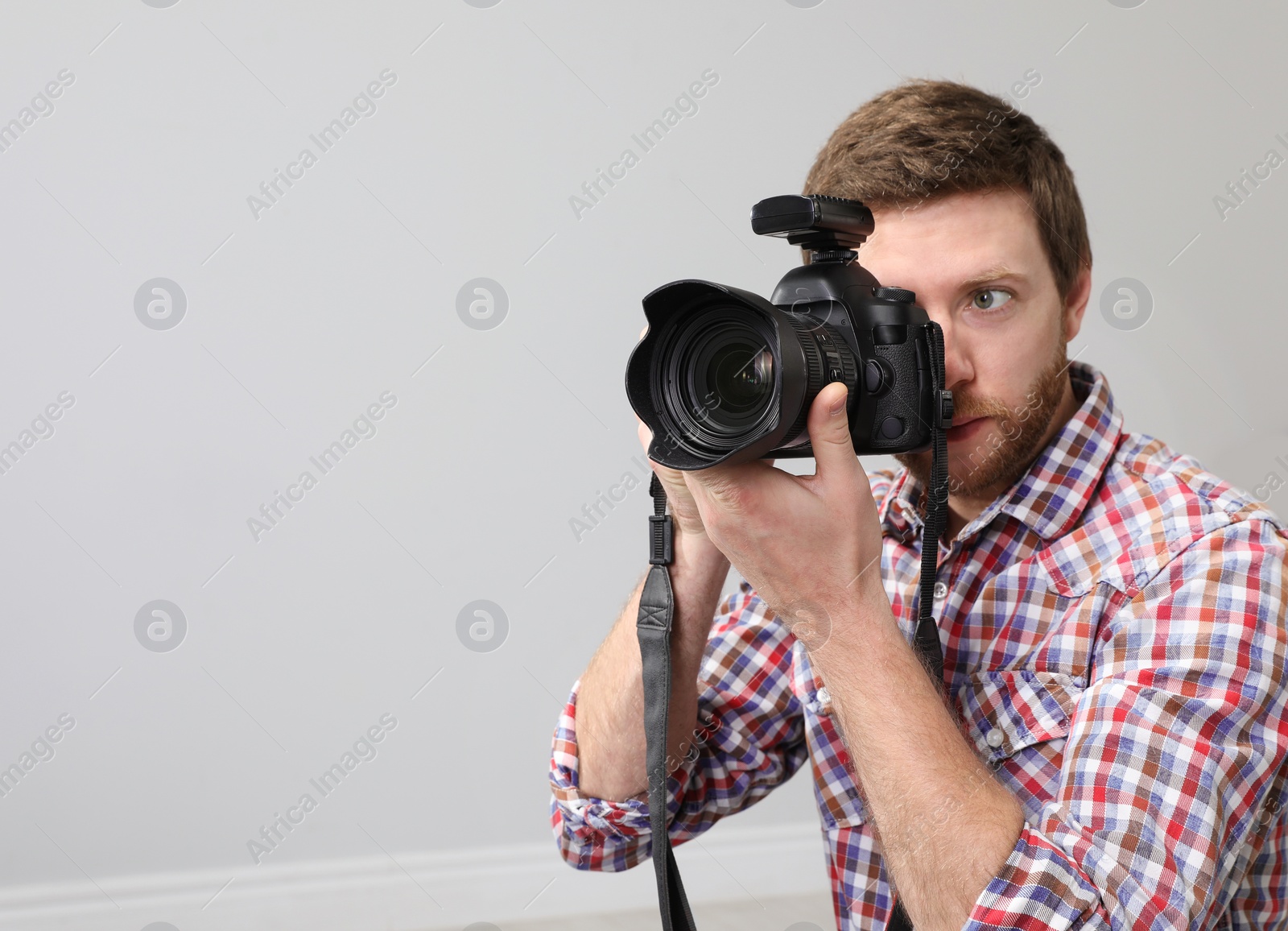 Photo of Man with professional camera in photo studio. Space for text
