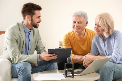 Male notary working with mature couple in office