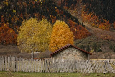 Picturesque view of house in mountains with forest on autumn day