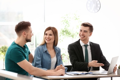 Photo of Young couple meeting with consultant in office