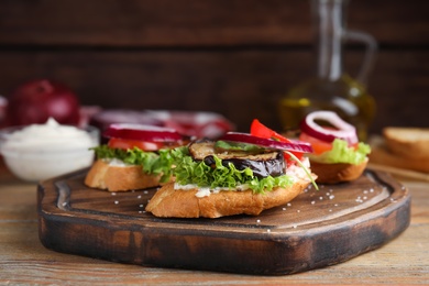 Photo of Delicious fresh eggplant sandwiches served on wooden table