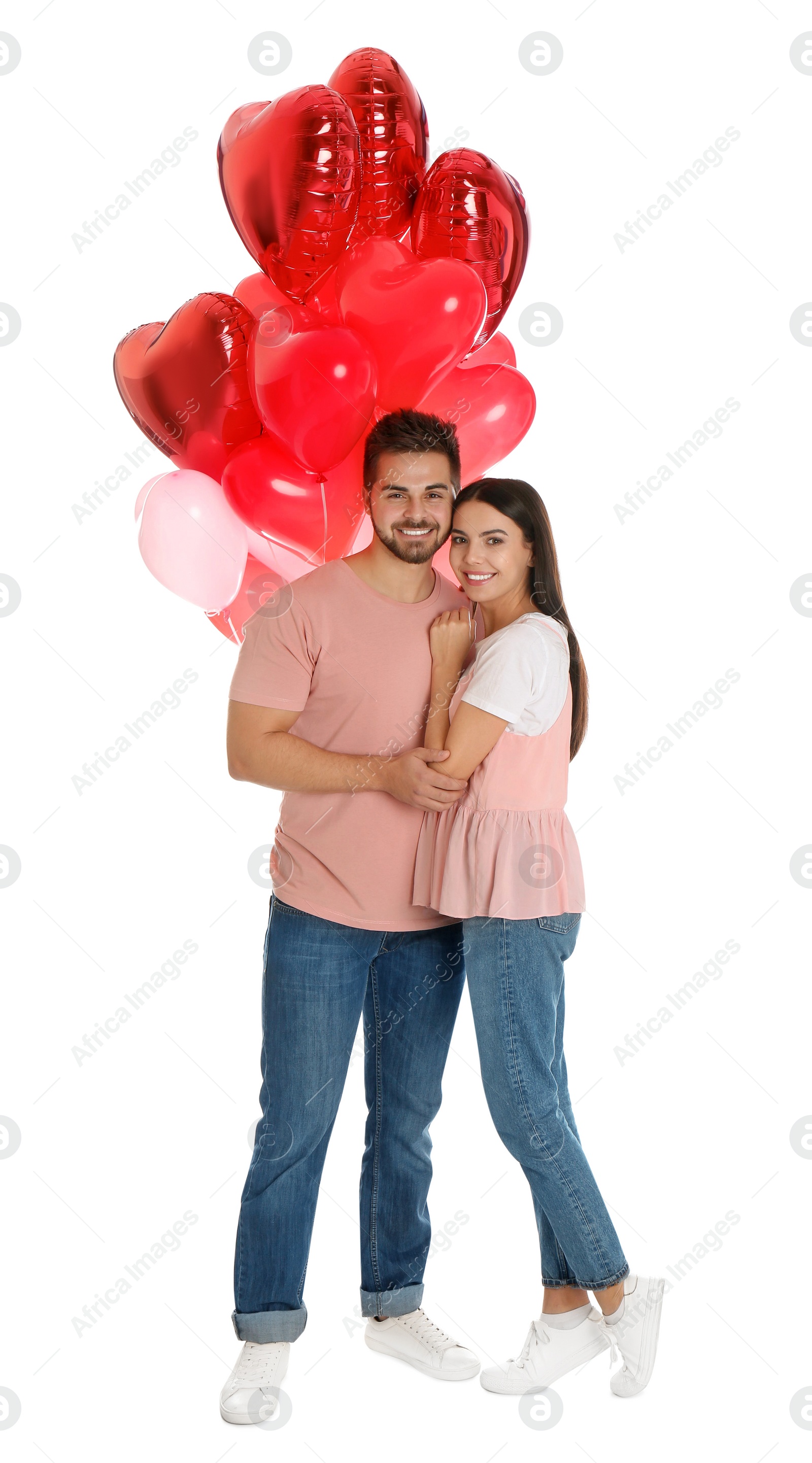 Photo of Happy young couple with heart shaped balloons isolated on white. Valentine's day celebration