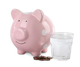Photo of Water scarcity concept. Piggy bank, glass of drink and coins isolated on white