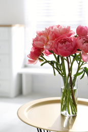 Beautiful bouquet of fragrant peonies in vase on table indoors