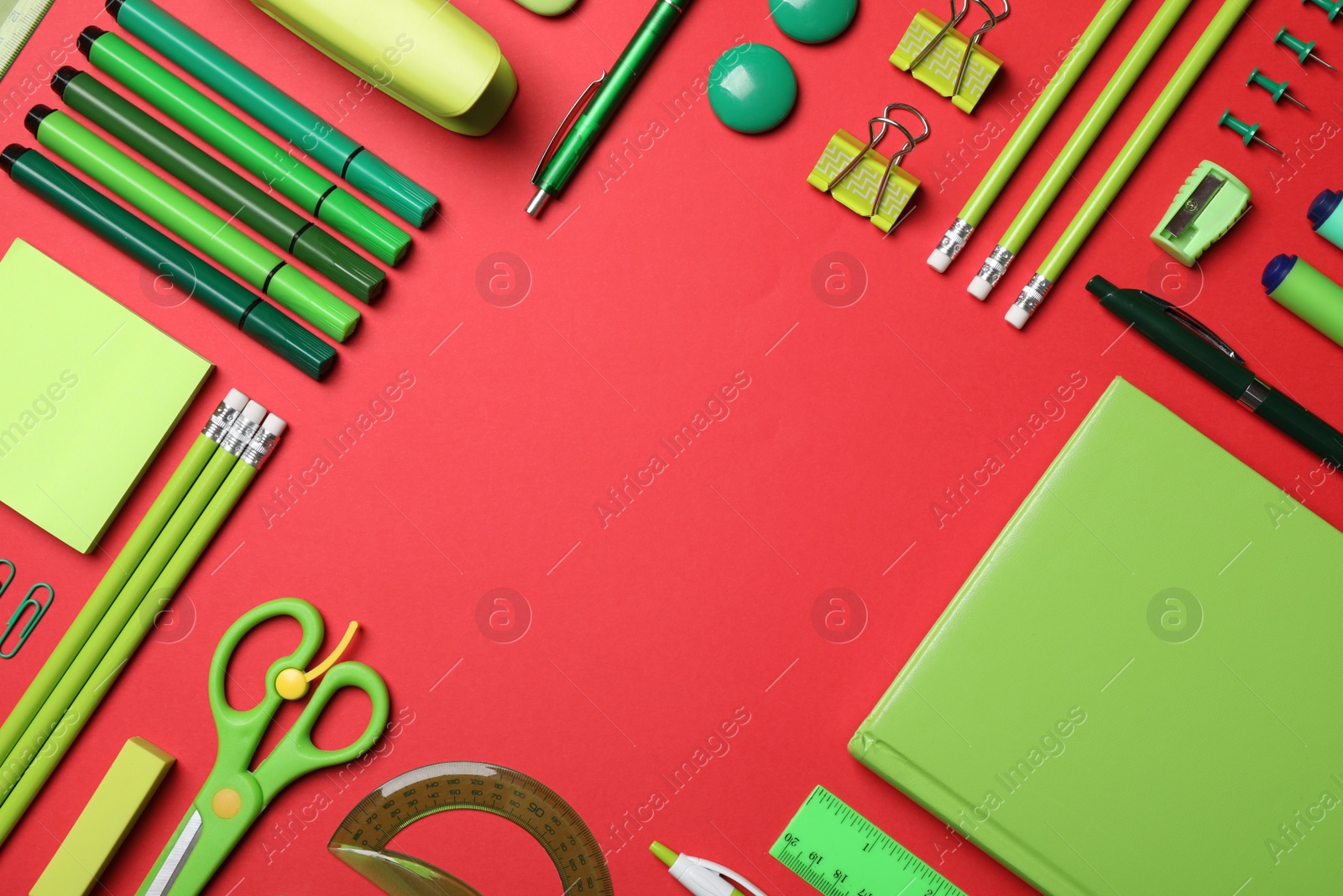 Photo of Frame of different stationery on red background, flat lay. Space for text