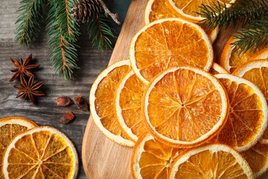 Dry orange slices, anise stars and fir tree branches on wooden table, flat lay