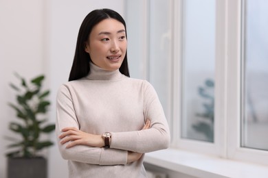 Portrait of smiling businesswoman with crossed arms in office