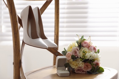 Composition with white wedding high heel shoes on wooden chair indoors