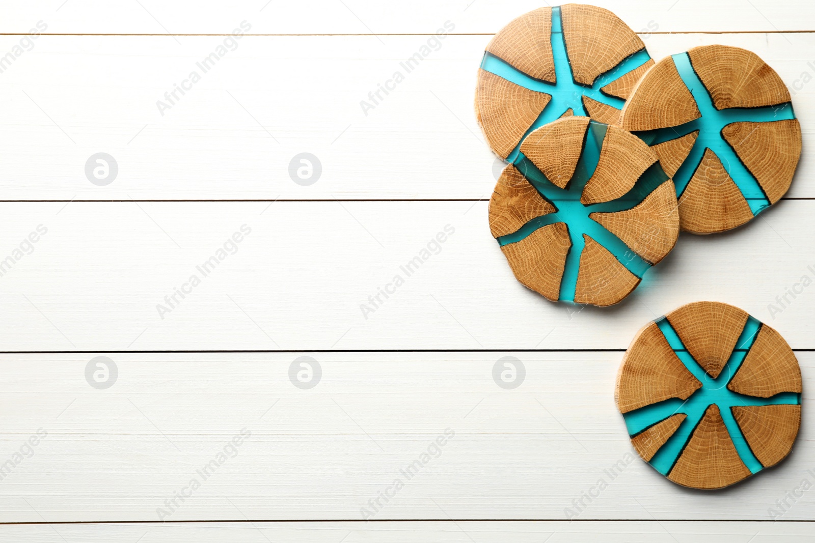 Photo of Stylish wooden cup coasters on white table, top view. Space for text