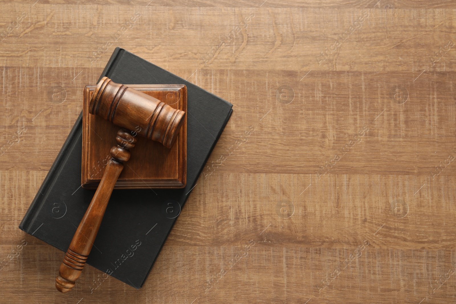 Photo of Law concept. Gavel and book on wooden table, top view. Space for text