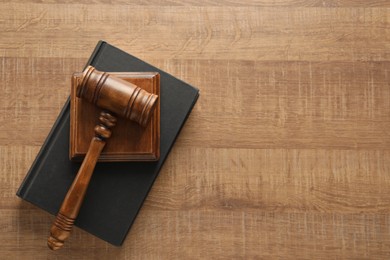 Photo of Law concept. Gavel and book on wooden table, top view. Space for text