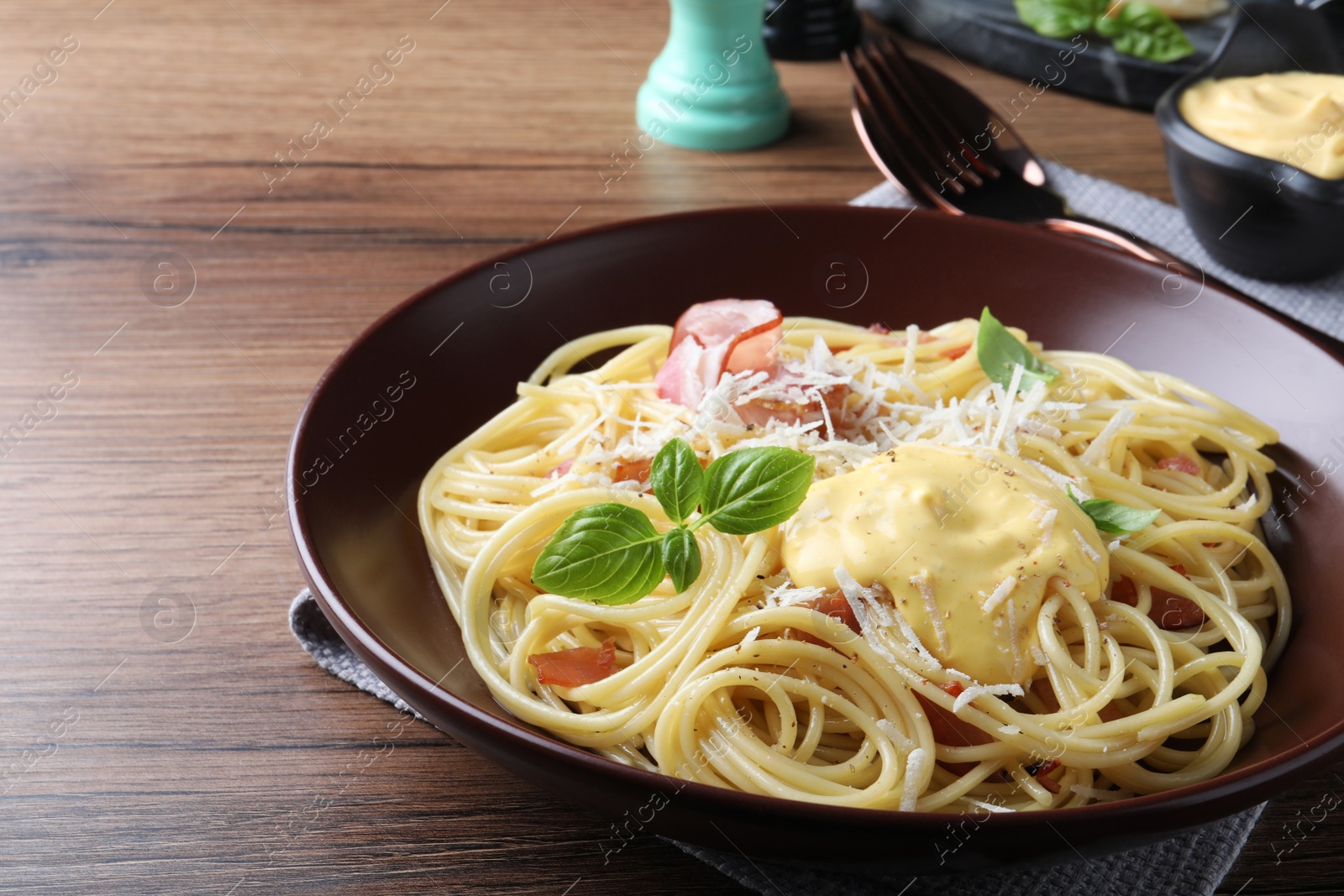 Photo of Delicious spaghetti with cheese sauce and meat on wooden table