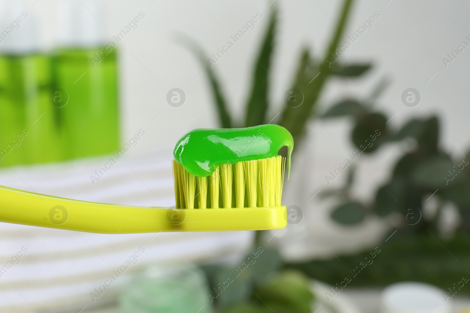 Photo of Toothbrush with aloe toothpaste on blurred background, closeup