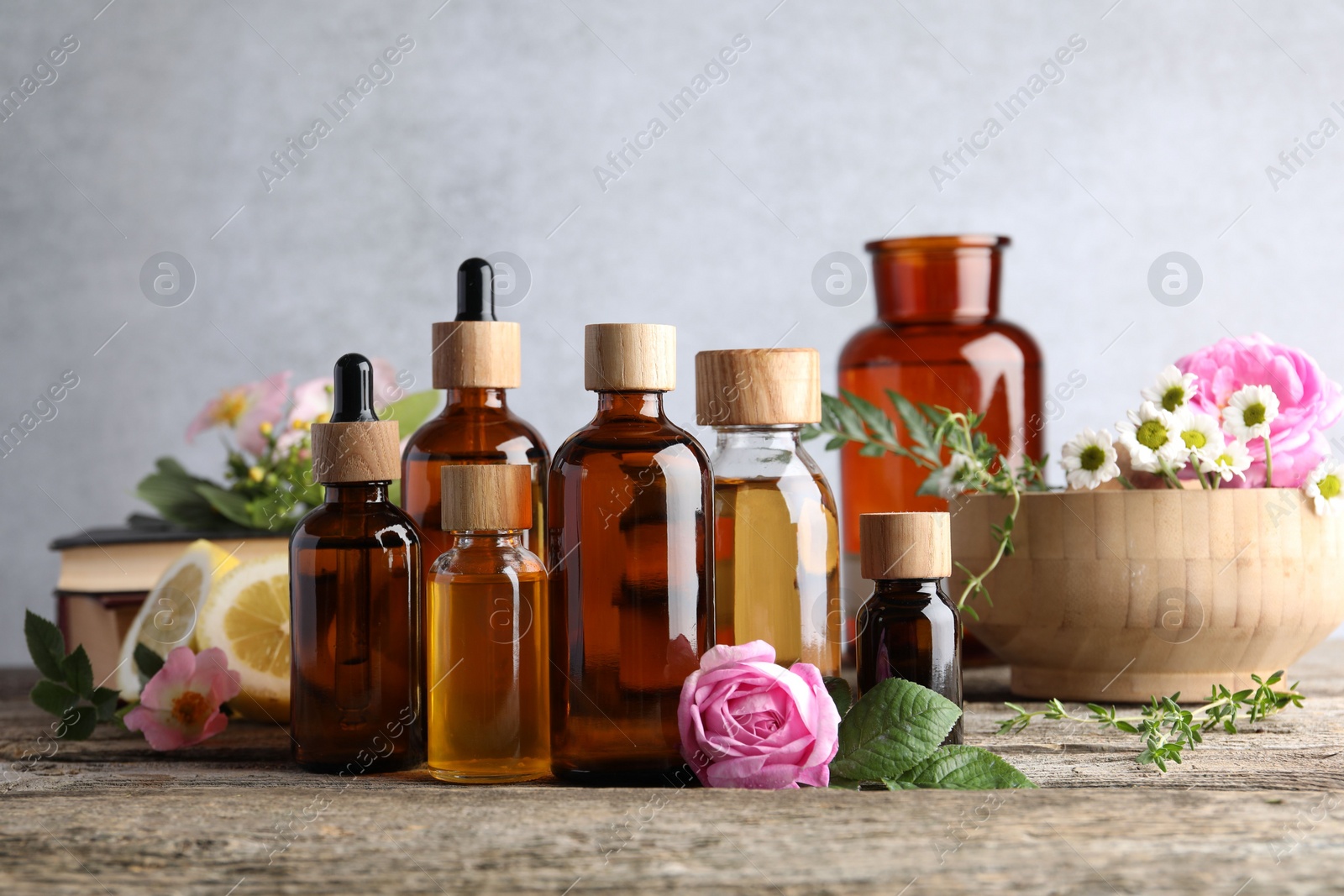 Photo of Aromatherapy. Different essential oils and flowers on wooden table