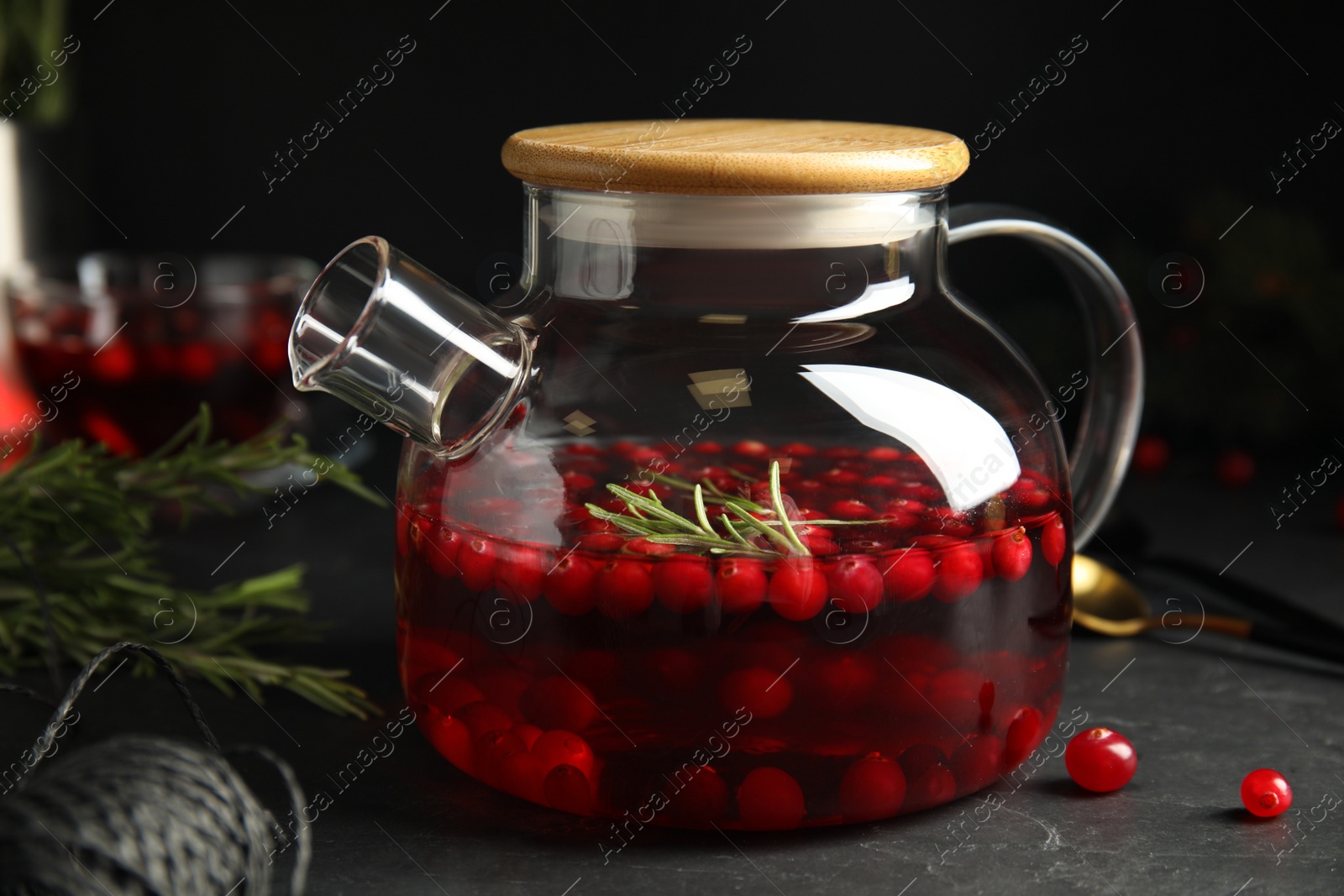 Photo of Tasty hot cranberry tea on black table