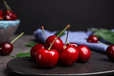 Photo of Board with ripe sweet cherries on table