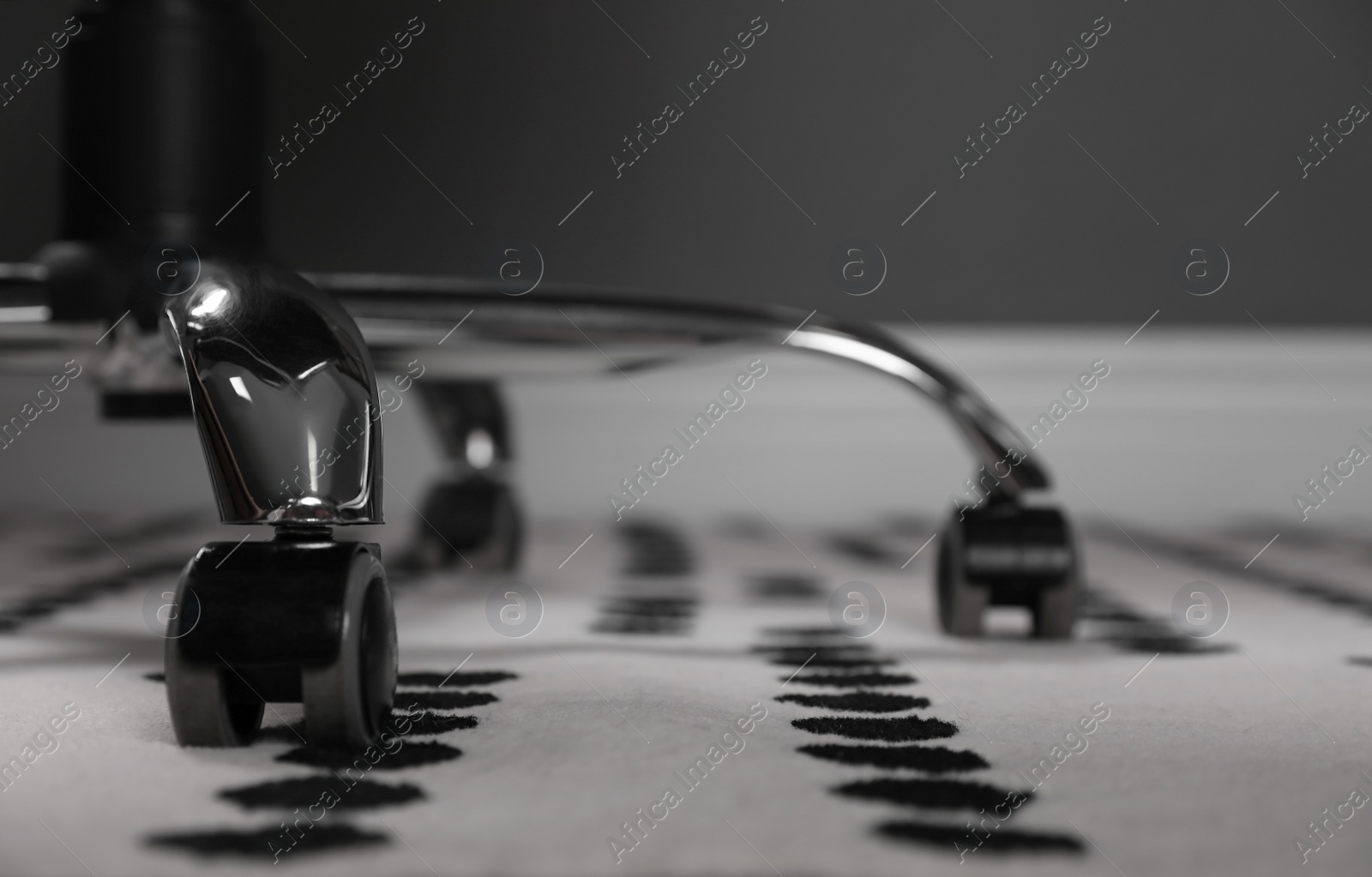 Photo of Modern office chair on carpet indoors, closeup. Base with casters