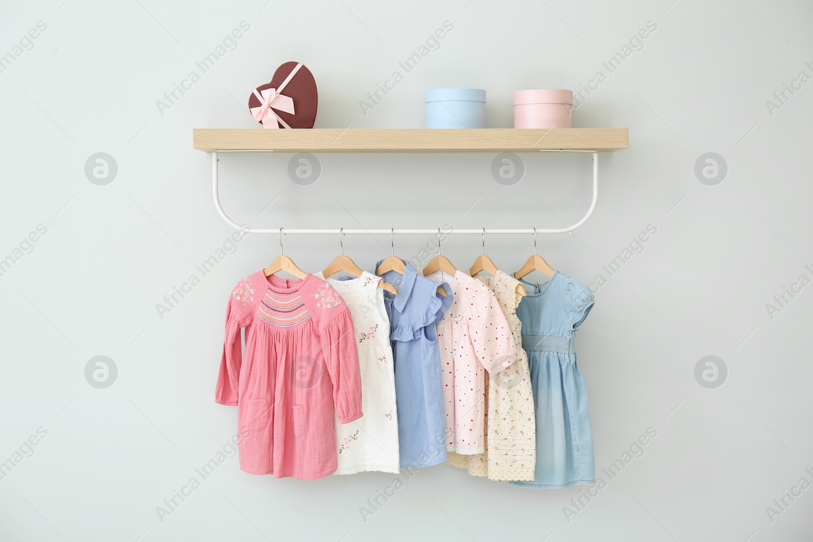 Photo of Rack with different clothes on light background