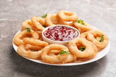 Photo of Fried onion rings served with sauce on plate