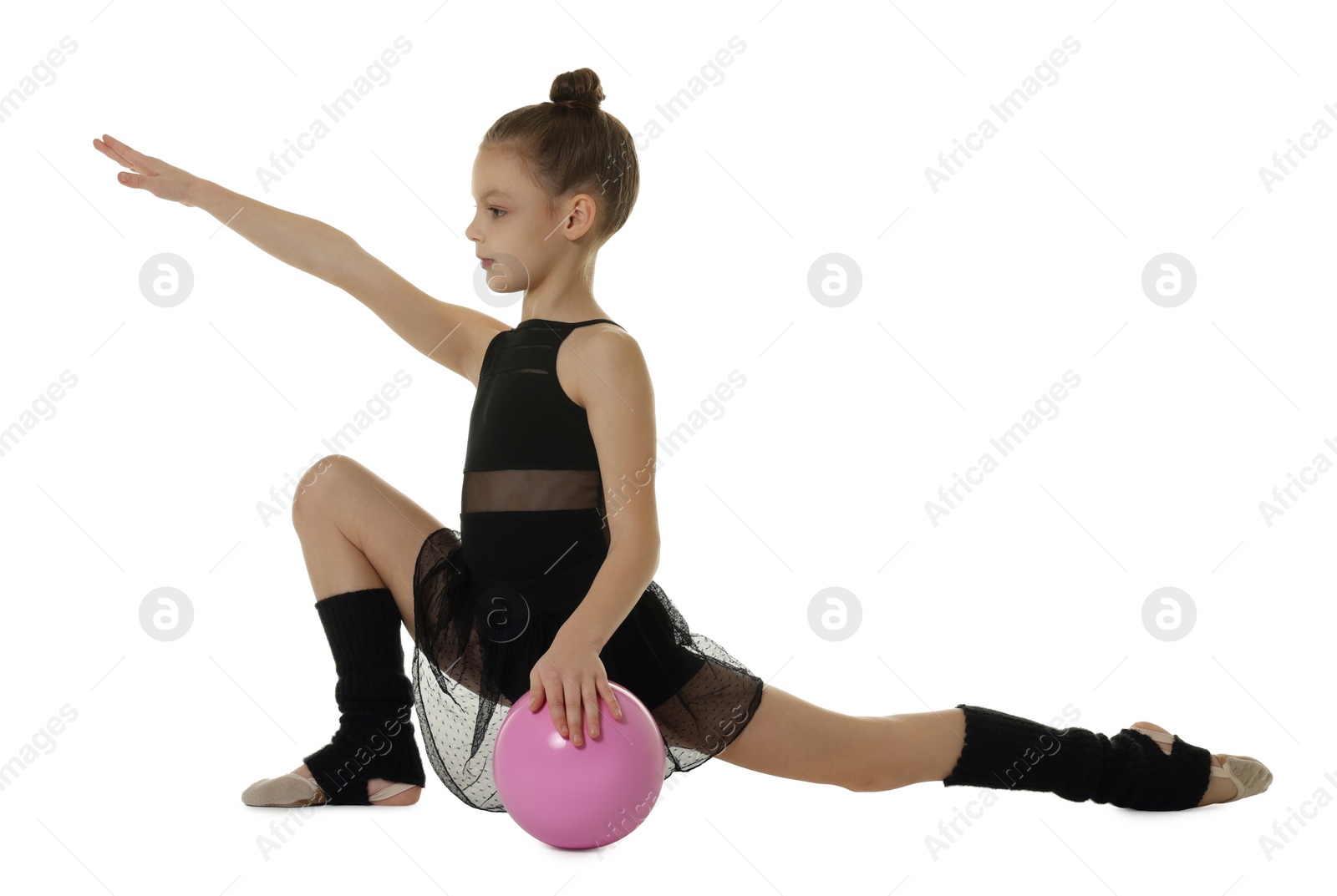 Photo of Cute little girl with ball doing gymnastic exercise on white background