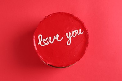 Photo of Bento cake with text Love You on red table, top view. St. Valentine's day surprise