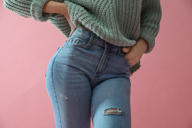 Photo of Woman wearing jeans on pink background, closeup