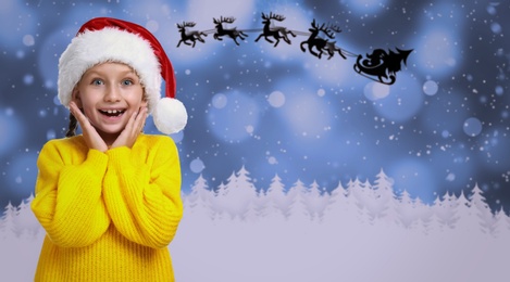 Cute little child and Santa Claus flying in his sleigh against moon sky on background. Christmas celebration