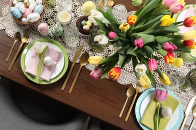 Photo of Festive table setting with beautiful flowers, top view. Easter celebration