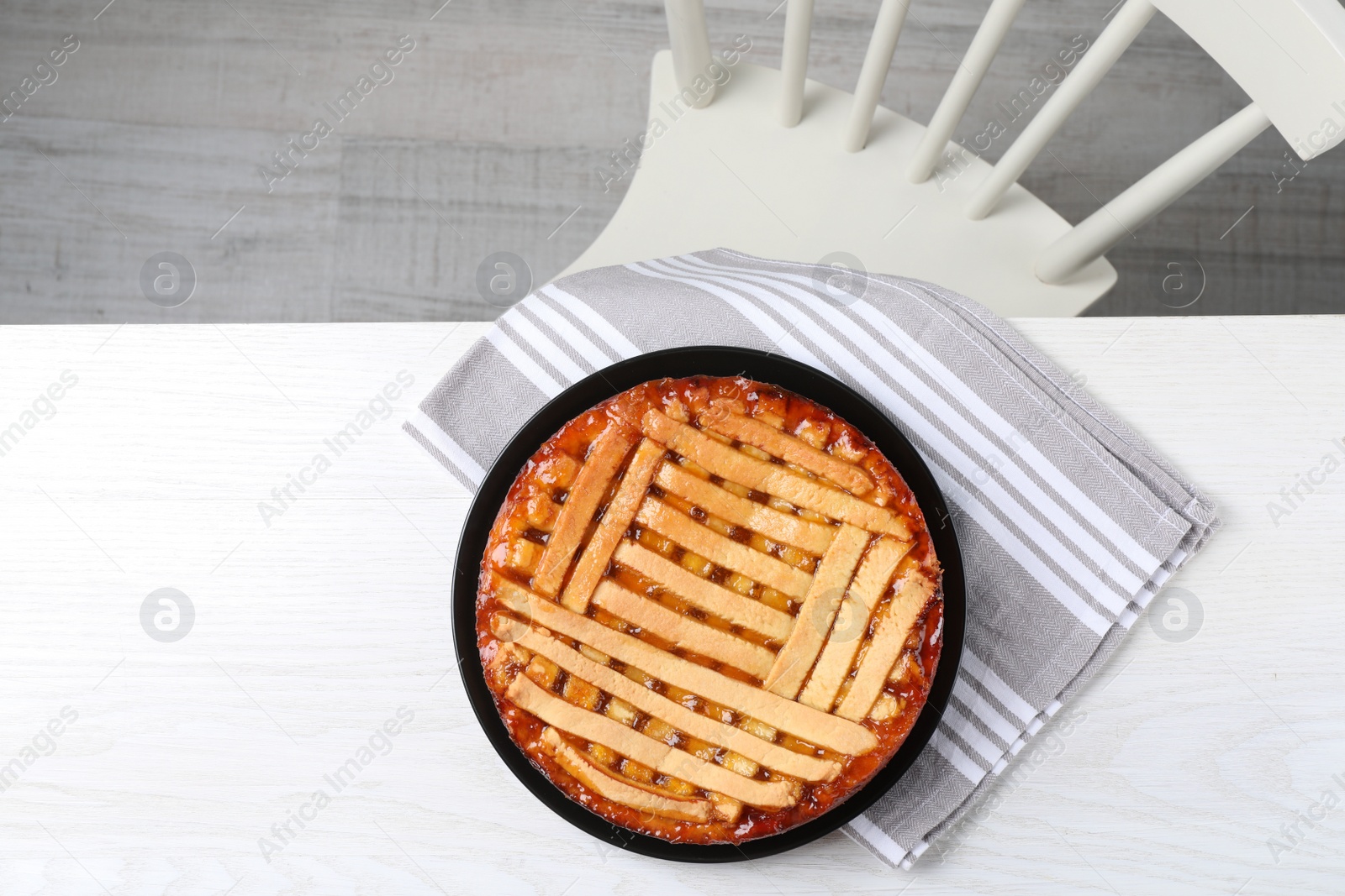 Photo of Tasty apricot pie on white wooden table, top view