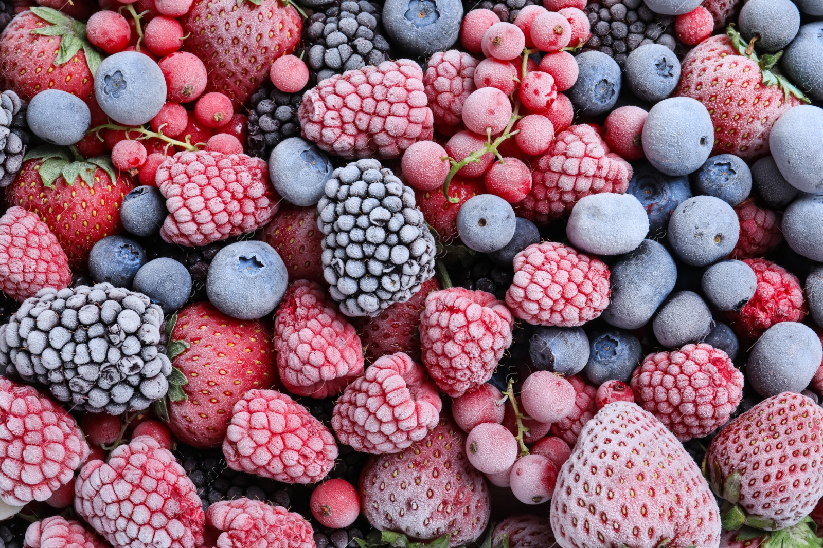 Photo of Mix of different frozen berries as background, top view